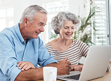 Älteres Ehepaar informiert sich am Laptop