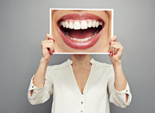 Frau hält ein Plakat mit einem lächelnden Mund nach oben.